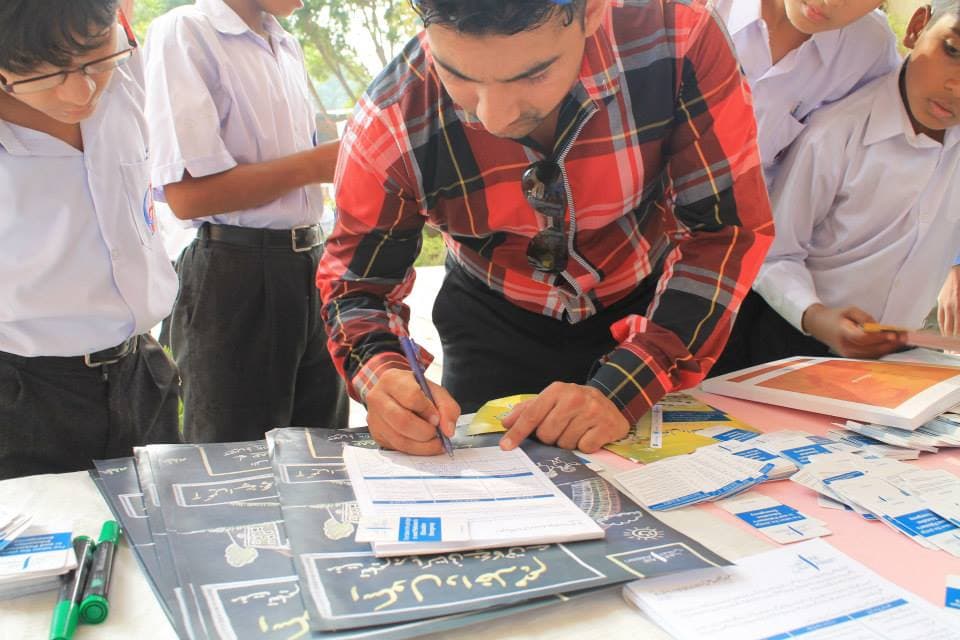 Young participant signing a pledge during a community journalism training