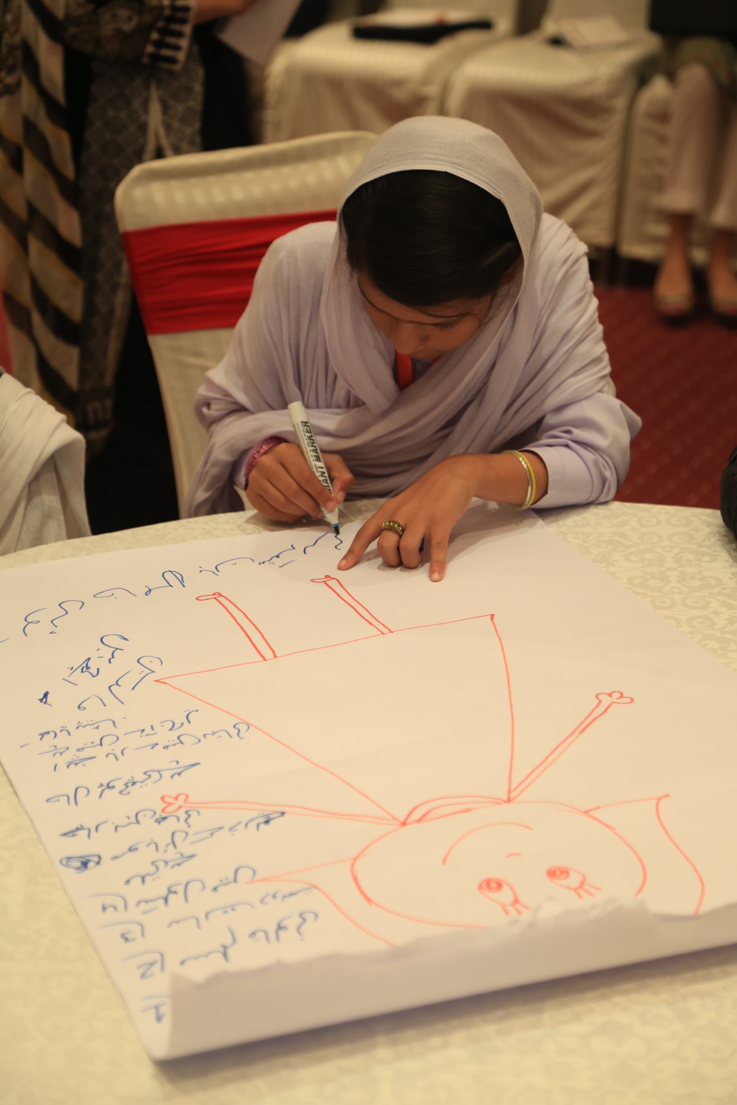 Girl presenting her illustration to the group during a design workshop