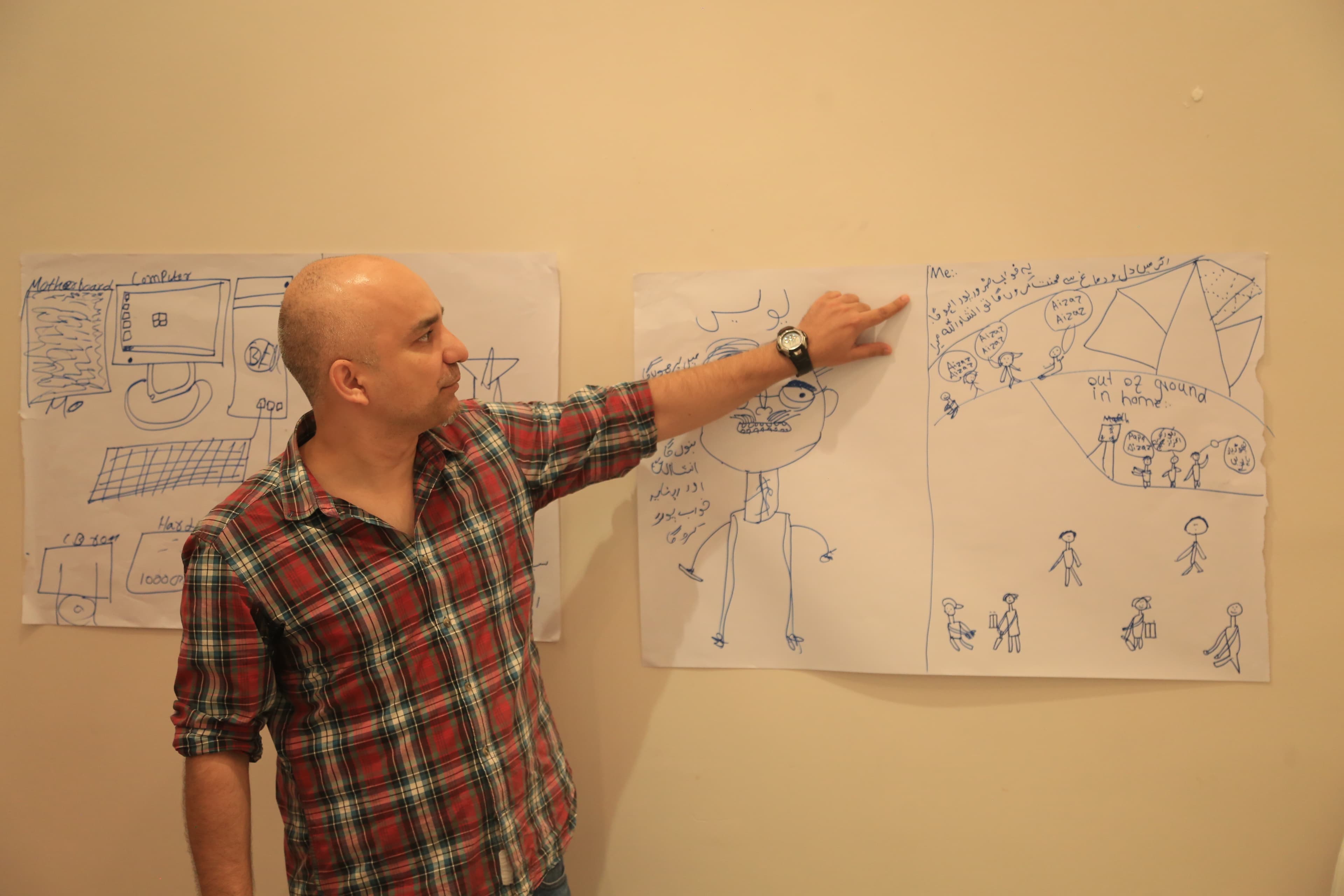 Facilitator and girls reviewing story concepts pinned to a classroom board