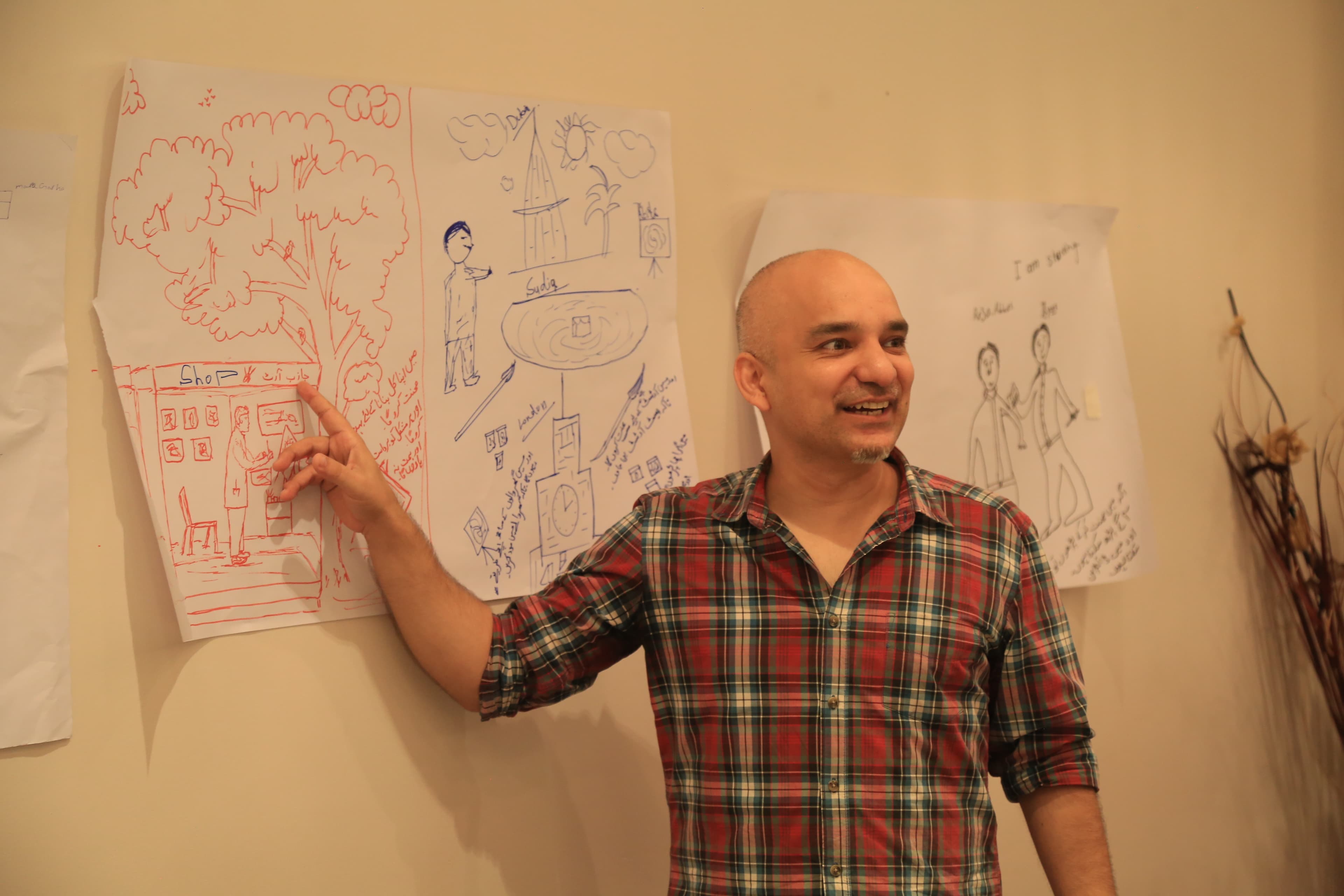 Design team member reviewing artwork produced by girls in the session