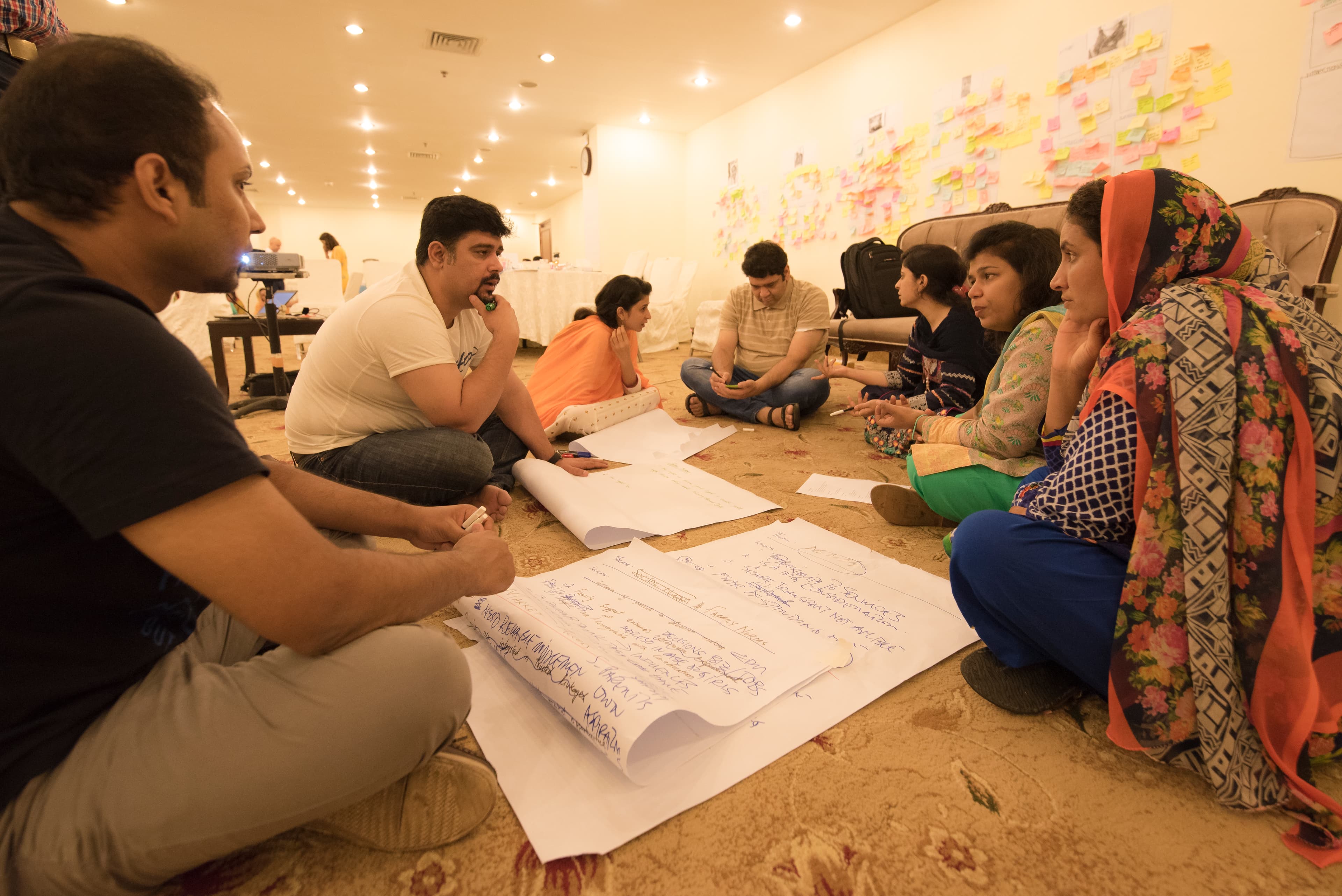 Facilitator guiding a group through a brainstorming exercise with sticky notes