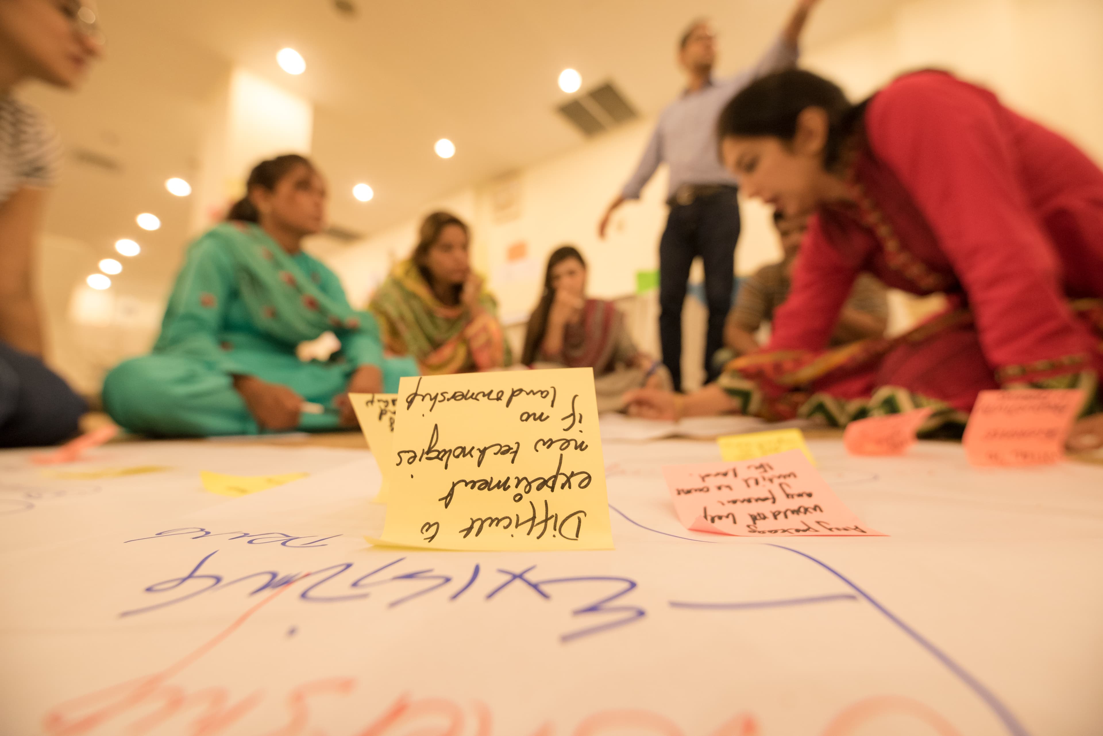 Close-up of hands arranging design thinking cards on a workshop table