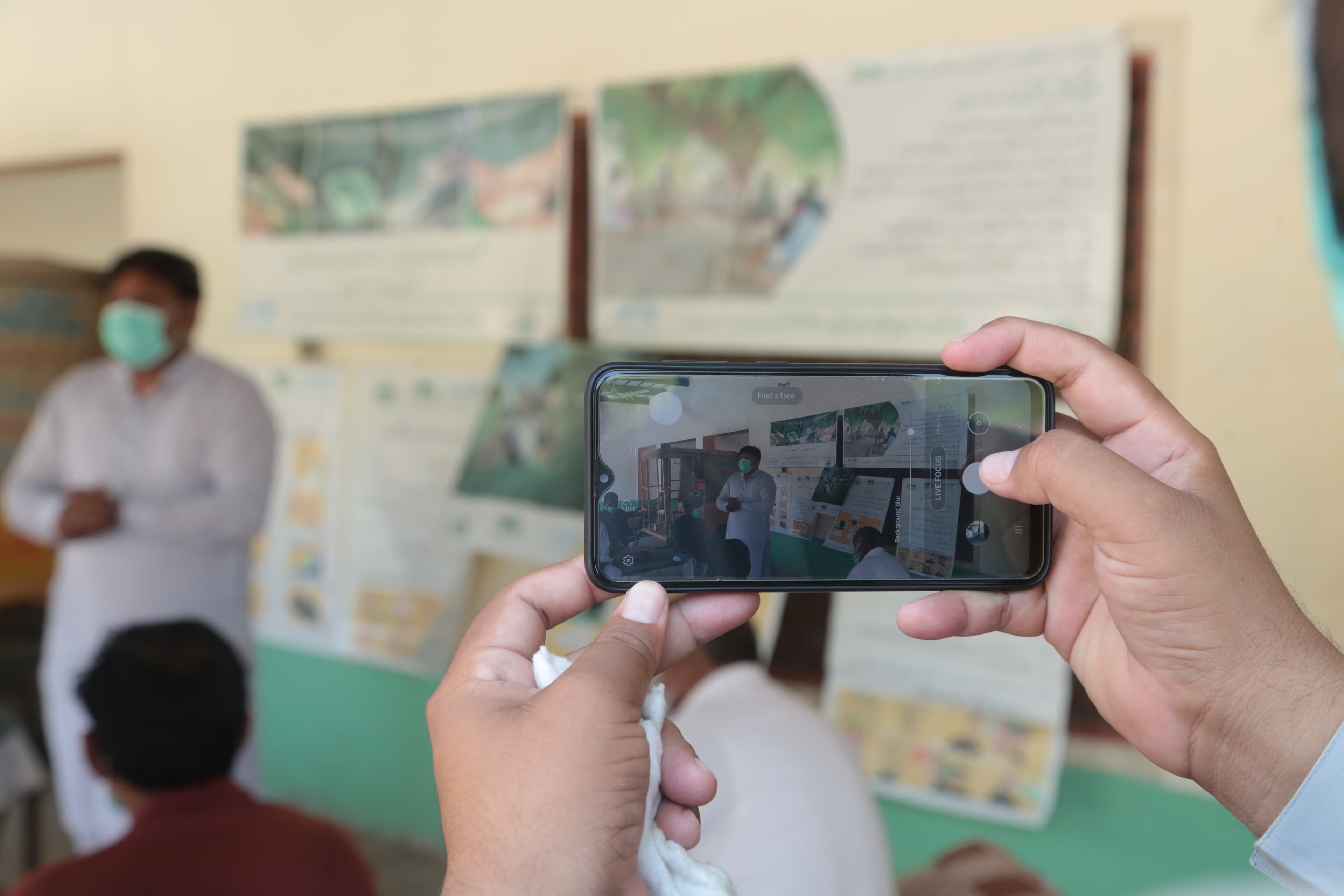 Community members painting environmental hygiene messages on a boundary wall